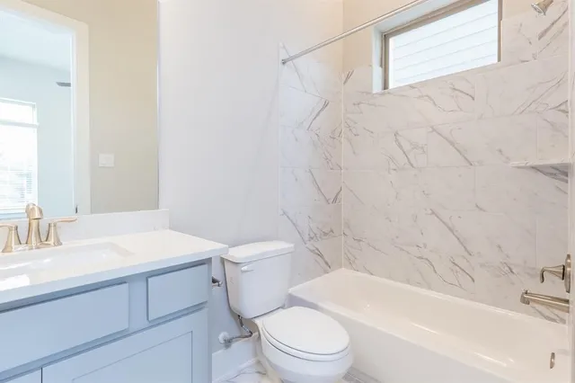 a bathroom with a tub shower and sink