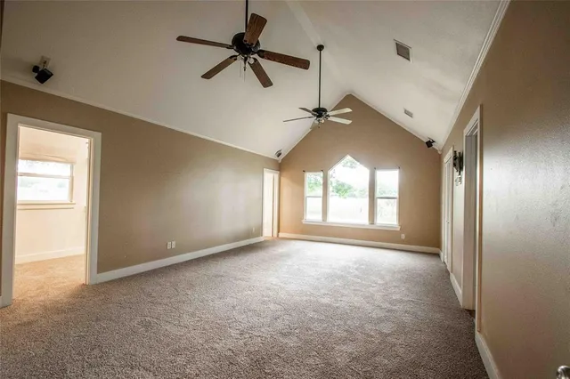 a view of empty room with windows and ceiling fan