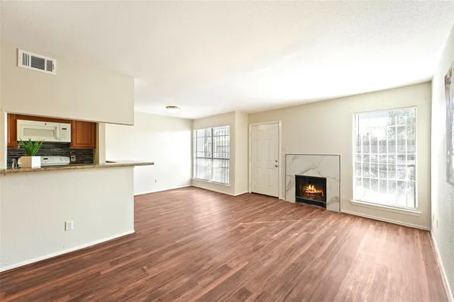 a view of empty room with wooden floor and fireplace