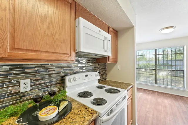 a kitchen with a stove and a wooden floor