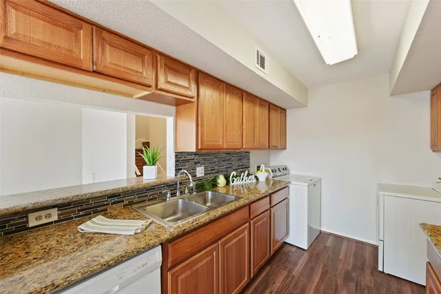 a kitchen with granite countertop stainless steel appliances a sink window and cabinets