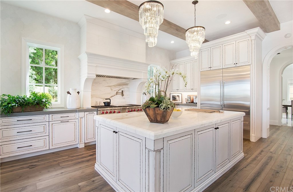 7 Rickie Lane Ladera Ranch, CA 92694 - Photo 9 of 36 a kitchen with kitchen island white cabinets stainless steel appliances and chandelier