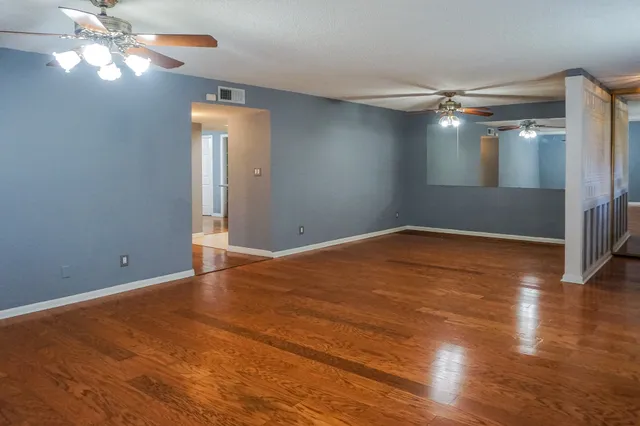 a view of empty room with wooden floor