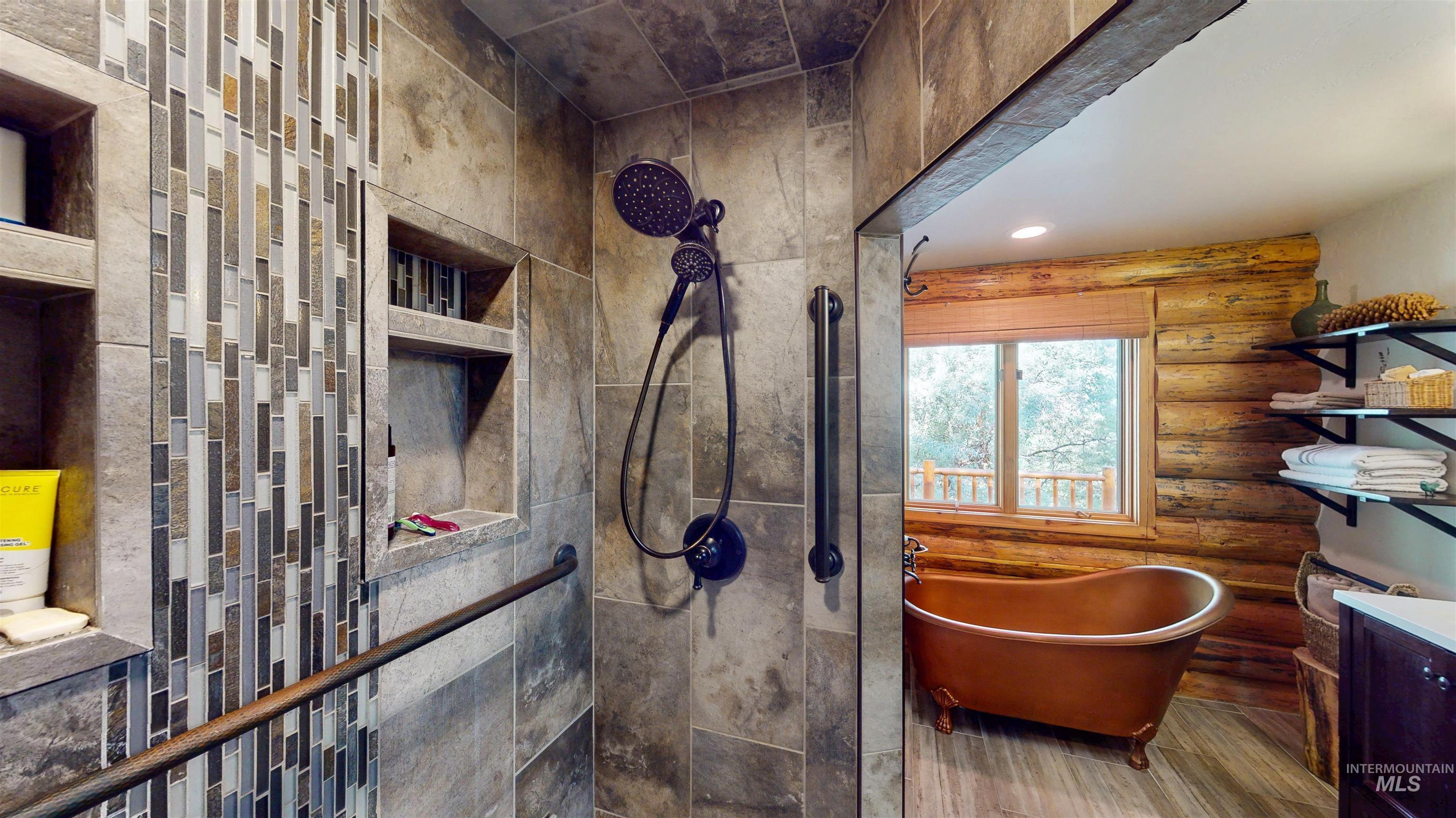 1314 River Road Buhl, ID 83316 - Photo 19 of 45 Bathroom with a soaking tub, wood finished floors, log walls, tiled shower, and vanity