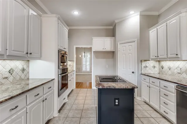 a kitchen with granite countertop a sink stove and cabinets