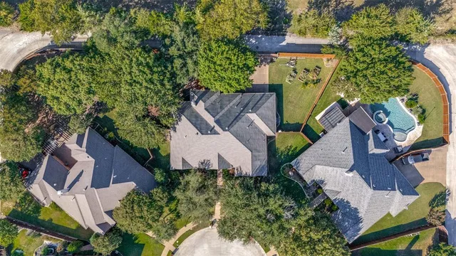 an aerial view of a house with a yard fire pit and outdoor seating