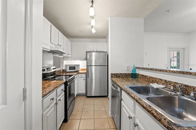 a bedroom with a bed chandelier and a window