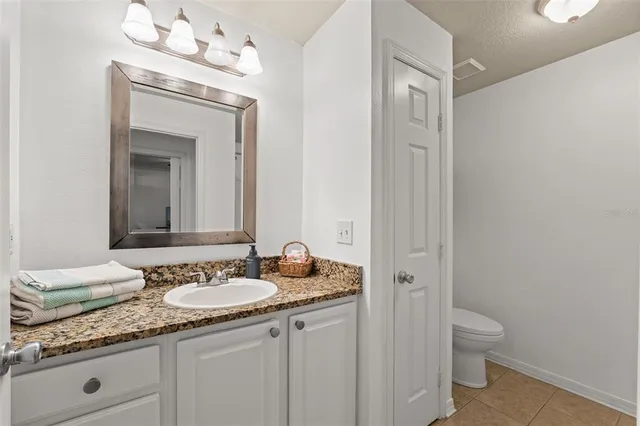 a en suite bathroom with a granite countertop sink and a mirror