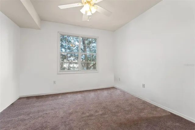 an empty room with closet and a chandelier fan