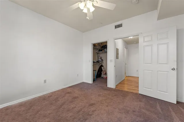 a view of an empty room with a chandelier fan
