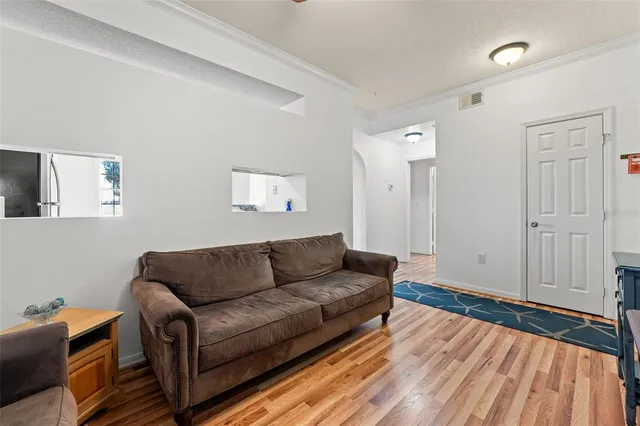 a living room with furniture and a wooden floor
