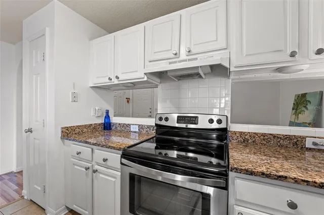 a kitchen with granite countertop a sink appliances and cabinets