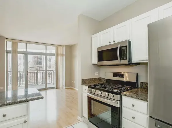 a kitchen with stainless steel appliances a stove a microwave and white cabinets