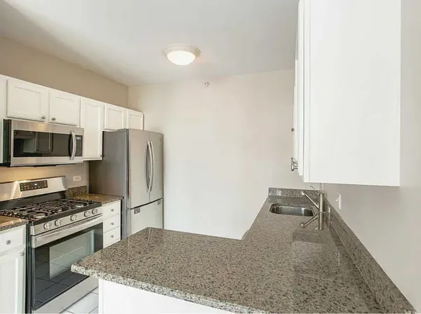 a kitchen with stainless steel appliances granite countertop a refrigerator stove and microwave