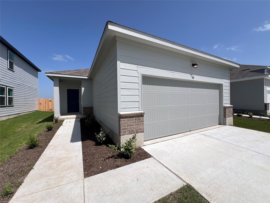 410 Plateau Street Maxwell, TX 78656 - Photo 2 of 14 a front view of a house with a yard and garage