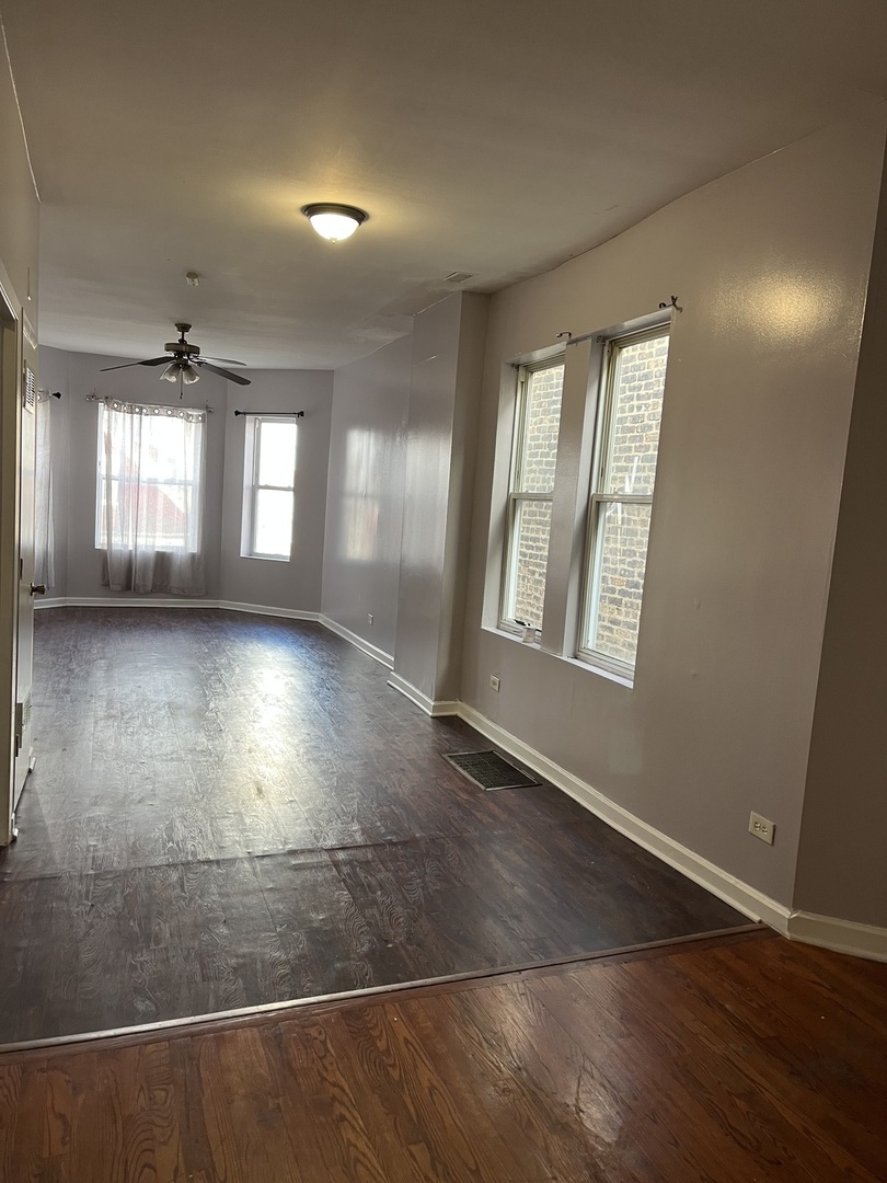 3057 West Flournoy Street, Unit 2 Chicago, IL 60612 - Photo 12 of 13 an empty room with wooden floor and windows