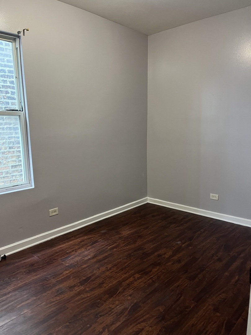 3057 West Flournoy Street, Unit 2 Chicago, IL 60612 - Photo 13 of 13 a view of an empty room with wooden floor and a window