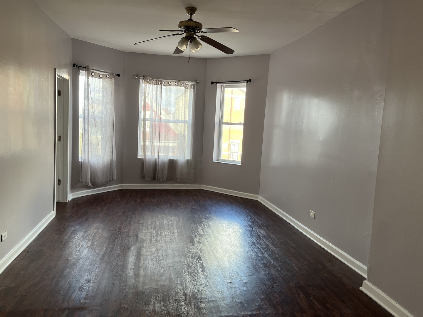 3057 West Flournoy Street, Unit 2 Chicago, IL 60612 - Photo 4 of 13 an empty room with wooden floor and windows