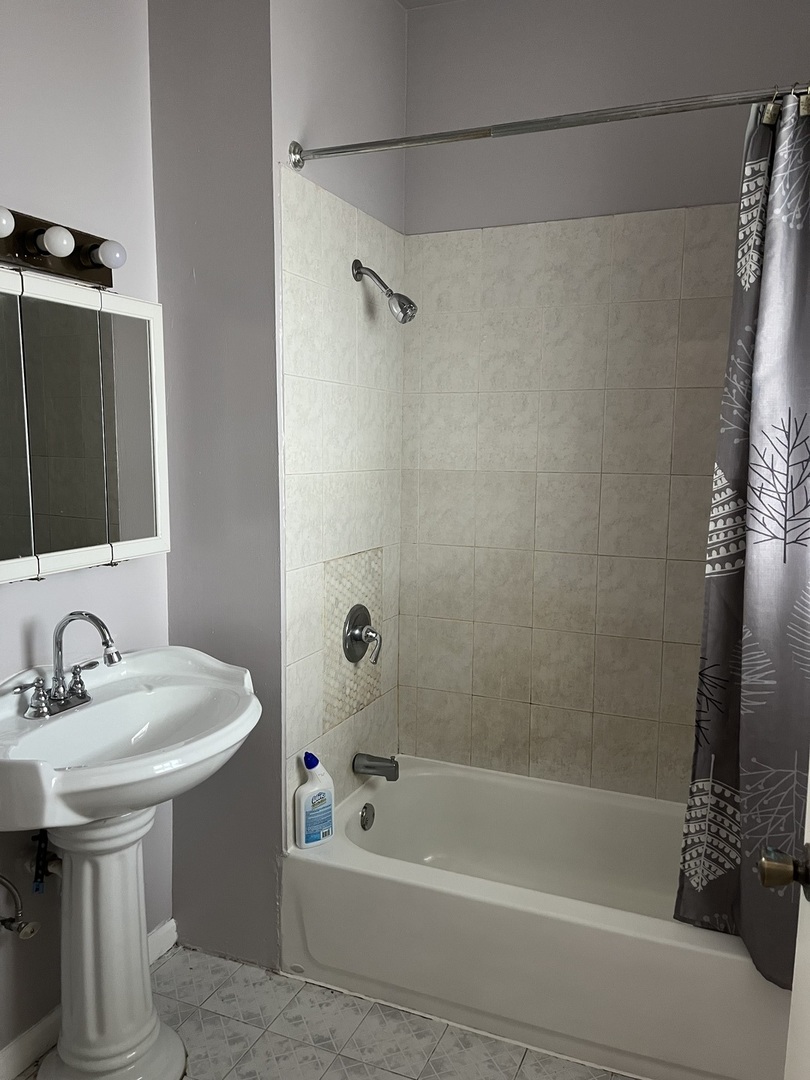 3057 West Flournoy Street, Unit 2 Chicago, IL 60612 - Photo 5 of 13 a bathroom with a sink a mirror and a bathtub