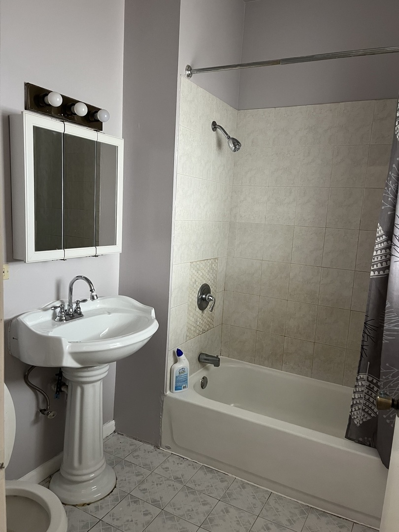 3057 West Flournoy Street, Unit 2 Chicago, IL 60612 - Photo 6 of 13 a bathroom with a sink a mirror toilet and bathtub