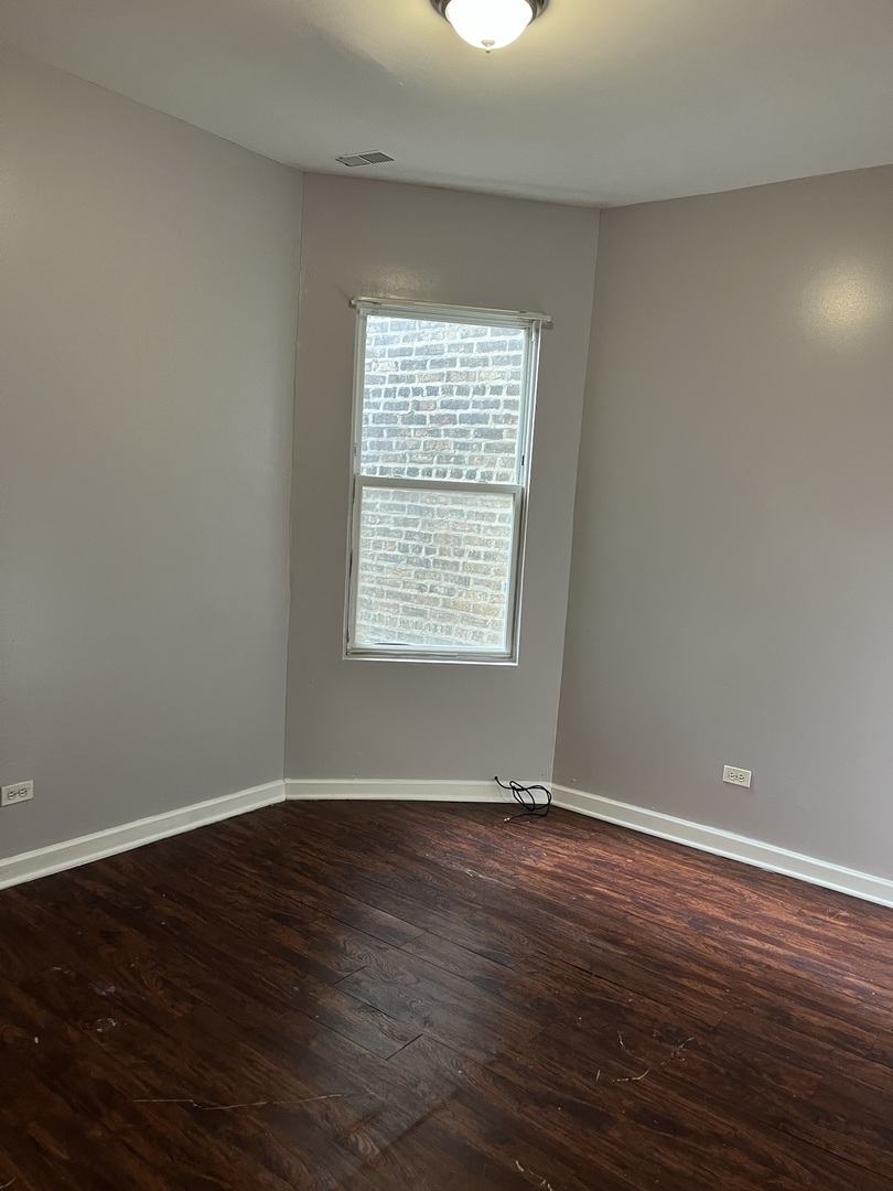 3057 West Flournoy Street, Unit 2 Chicago, IL 60612 - Photo 10 of 13 a view of an empty room with wooden floor and a window