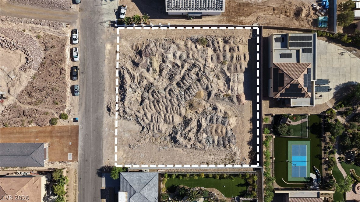 1243 Gloria Mountain Road Henderson, NV 89002 - Photo 12 of 12 A spacious, vacant lot awaits development, bordered by established homes and community features.