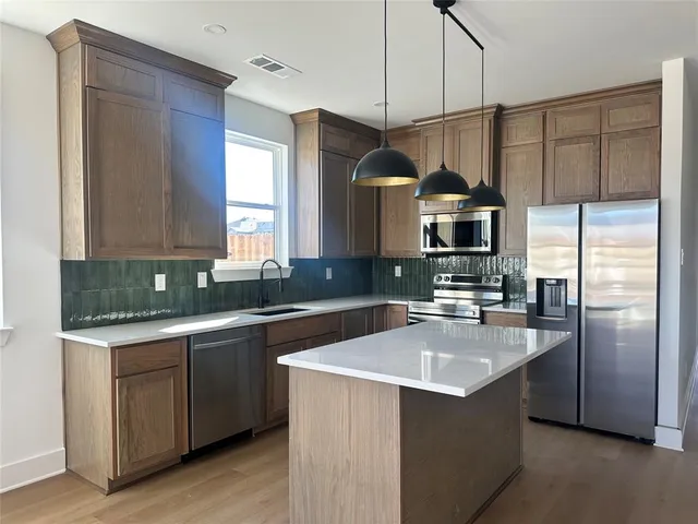 a kitchen with a sink a counter space appliances and cabinets
