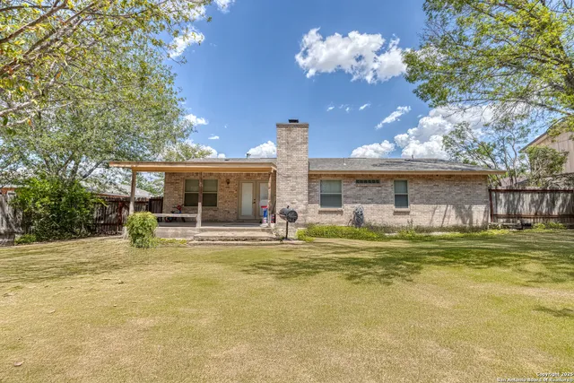 a view of a house with backyard and sitting area