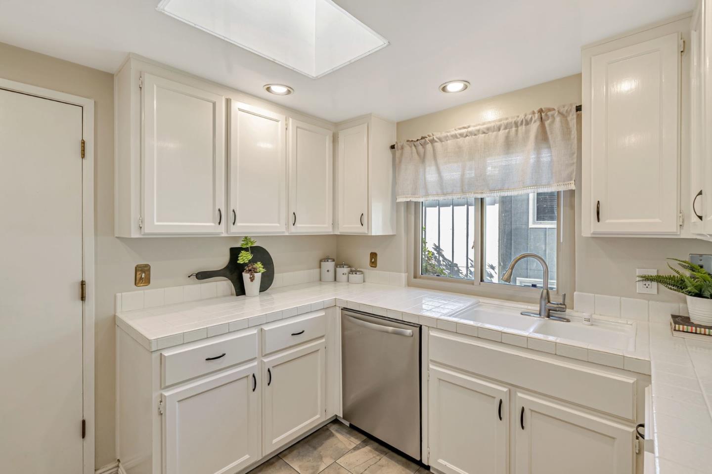 42 Weepingridge Court San Mateo, CA 94402 - Photo 11 of 45 a kitchen with white cabinets white appliances and sink