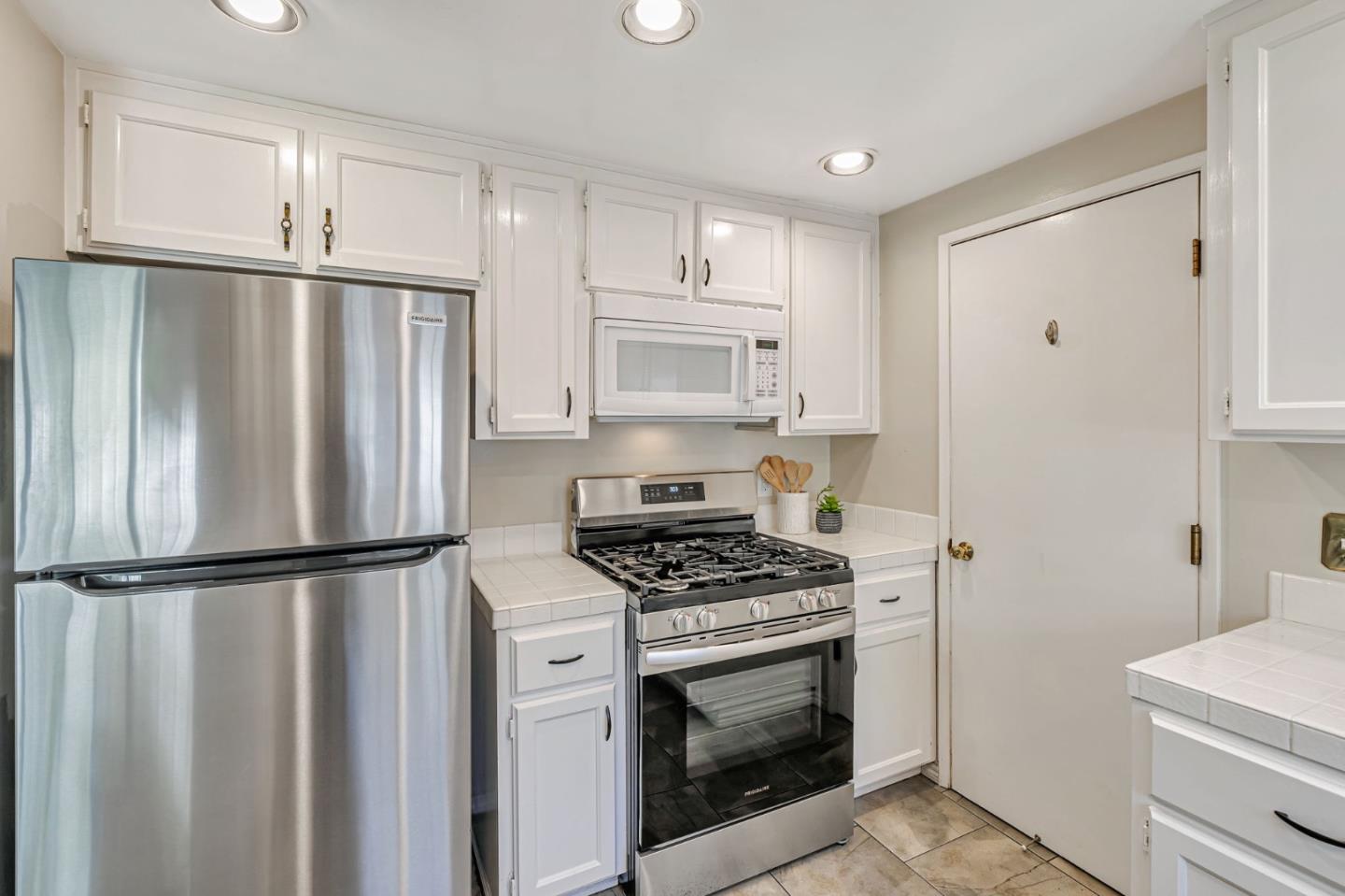 42 Weepingridge Court San Mateo, CA 94402 - Photo 10 of 45 a kitchen with granite countertop a refrigerator stove and white cabinets
