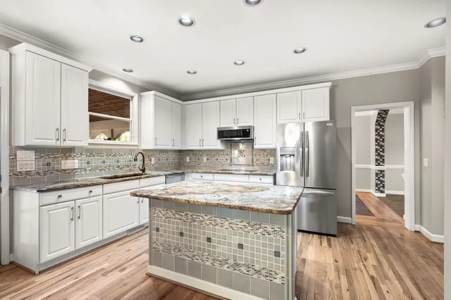 a kitchen with stainless steel appliances granite countertop a refrigerator and a stove top oven