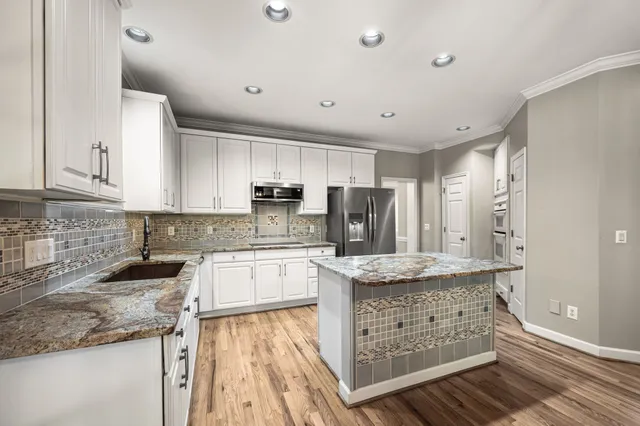 a kitchen with stainless steel appliances granite countertop a refrigerator sink and microwave