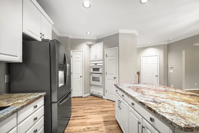 a kitchen with white cabinets and stainless steel appliances