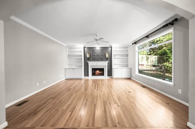 a view of empty room with a fireplace and wooden floor