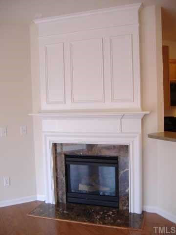 8616 Redcrest Place, Unit 100 Raleigh, NC 27617 - Photo 3 of 6 Corner gas fireplace with trim work details and marble surround Other