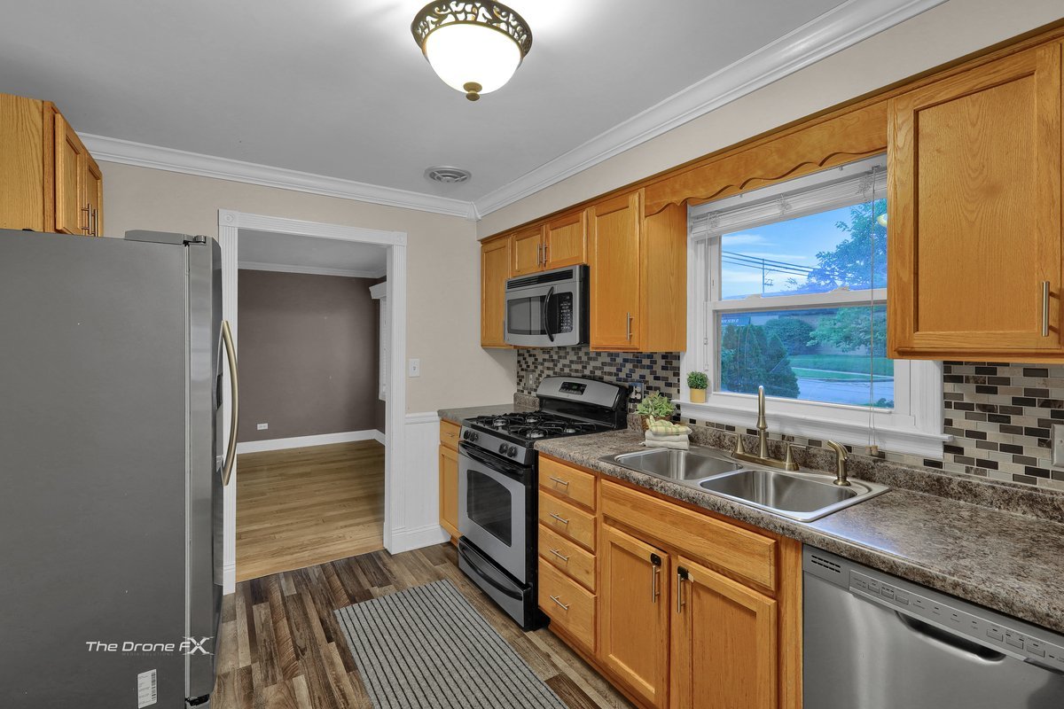 714 Delles Road Wheaton, IL 60189 - Photo 6 of 18 a kitchen with stainless steel appliances granite countertop a sink stove and cabinets