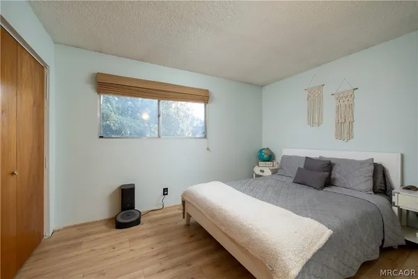 a bedroom with a bed and wooden floor