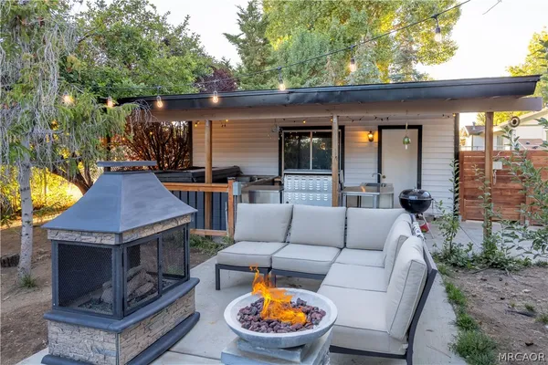 a view of a patio with couches table and chairs and potted plants