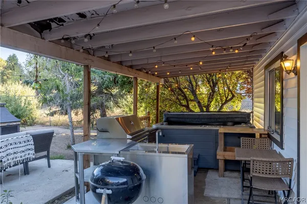 a view of a porch with furniture and a yard