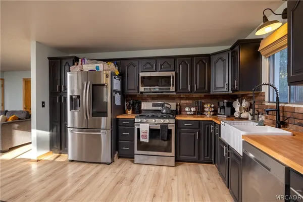 a kitchen with stainless steel appliances granite countertop a refrigerator a stove top oven a sink and dishwasher