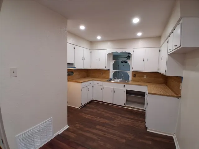 a kitchen with granite countertop a sink and cabinets