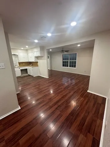 a view of empty room with wooden floor