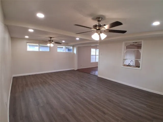 a view of a livingroom with a ceiling fan window and wooden floor