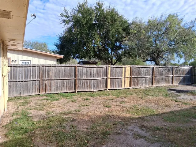 a view of backyard with wooden fence