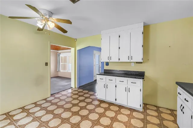 a kitchen with granite countertop a stove a sink a refrigerator and cabinets
