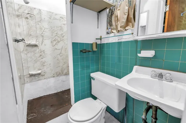 a bathroom with a sink a toilet and shower