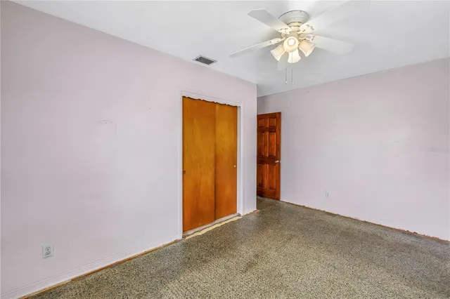 an empty room with a chandelier fan and a chandelier fan