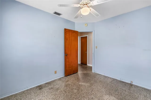 an empty room with a ceiling fan and a window