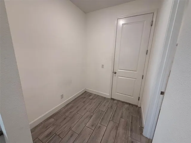 a view of a small space with wooden floor and a ceiling fan