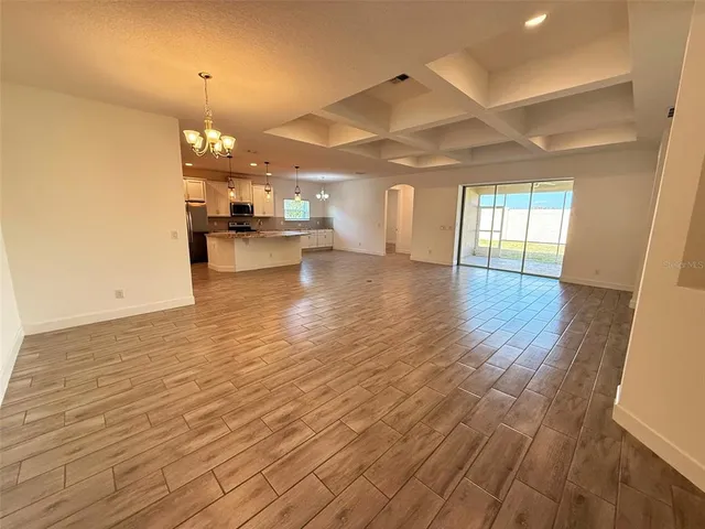 a view of a living room a kitchen and a wooden floor